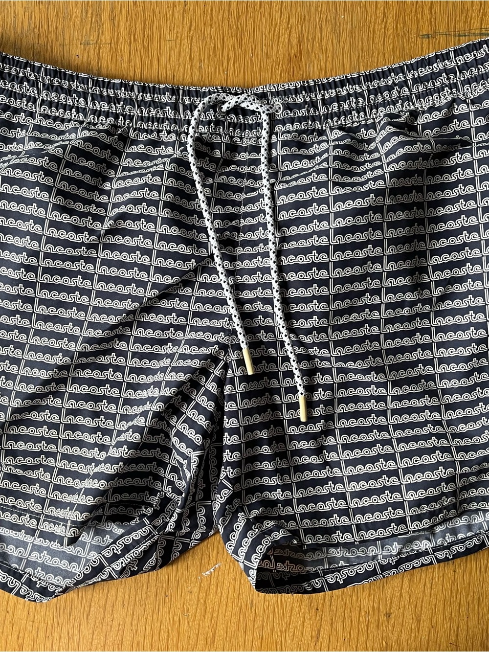 Lacoste Blue and White All-Over Logo Swim Trunks.